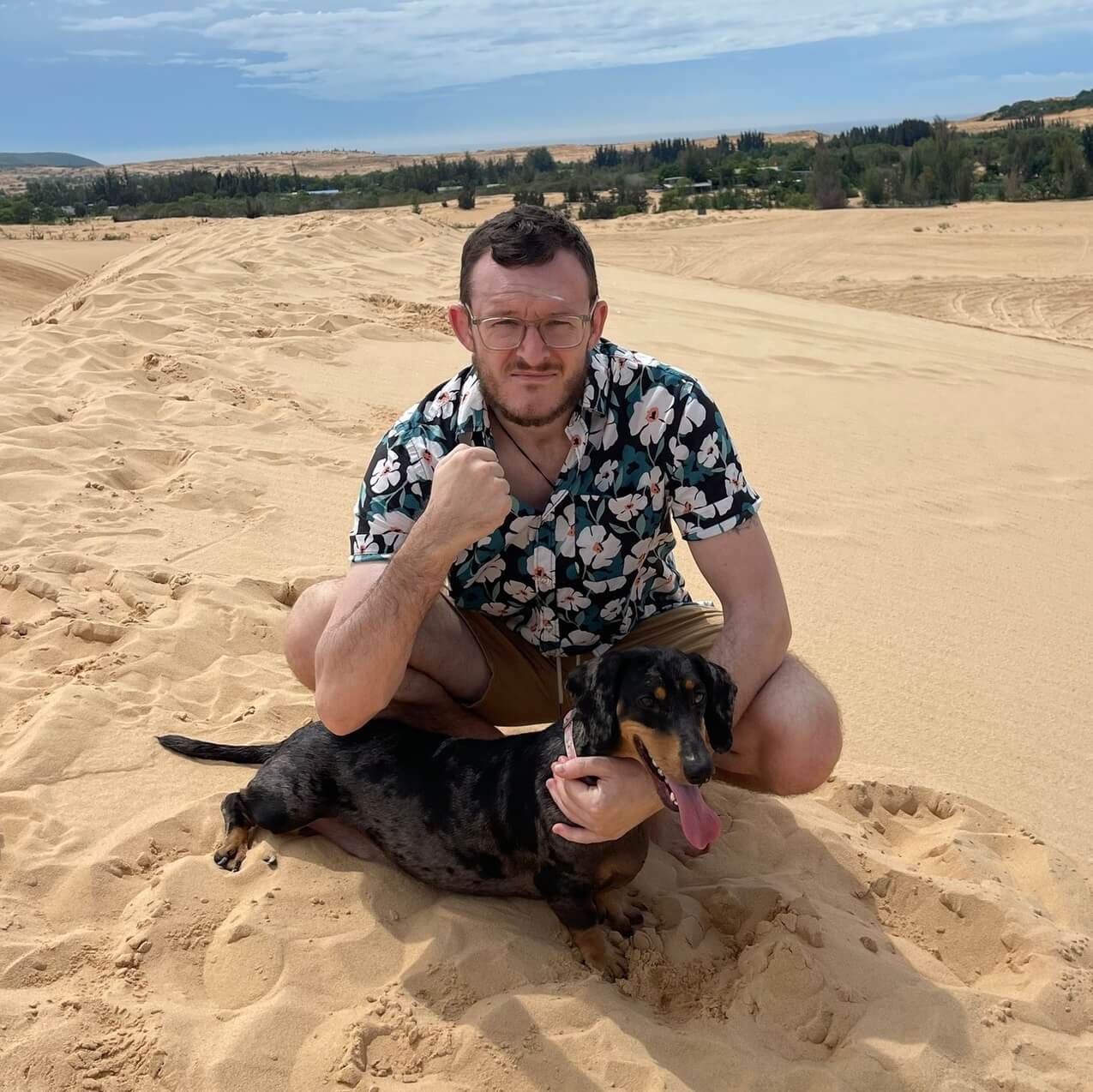 Andrew Buck on sand dunes with a dachshund